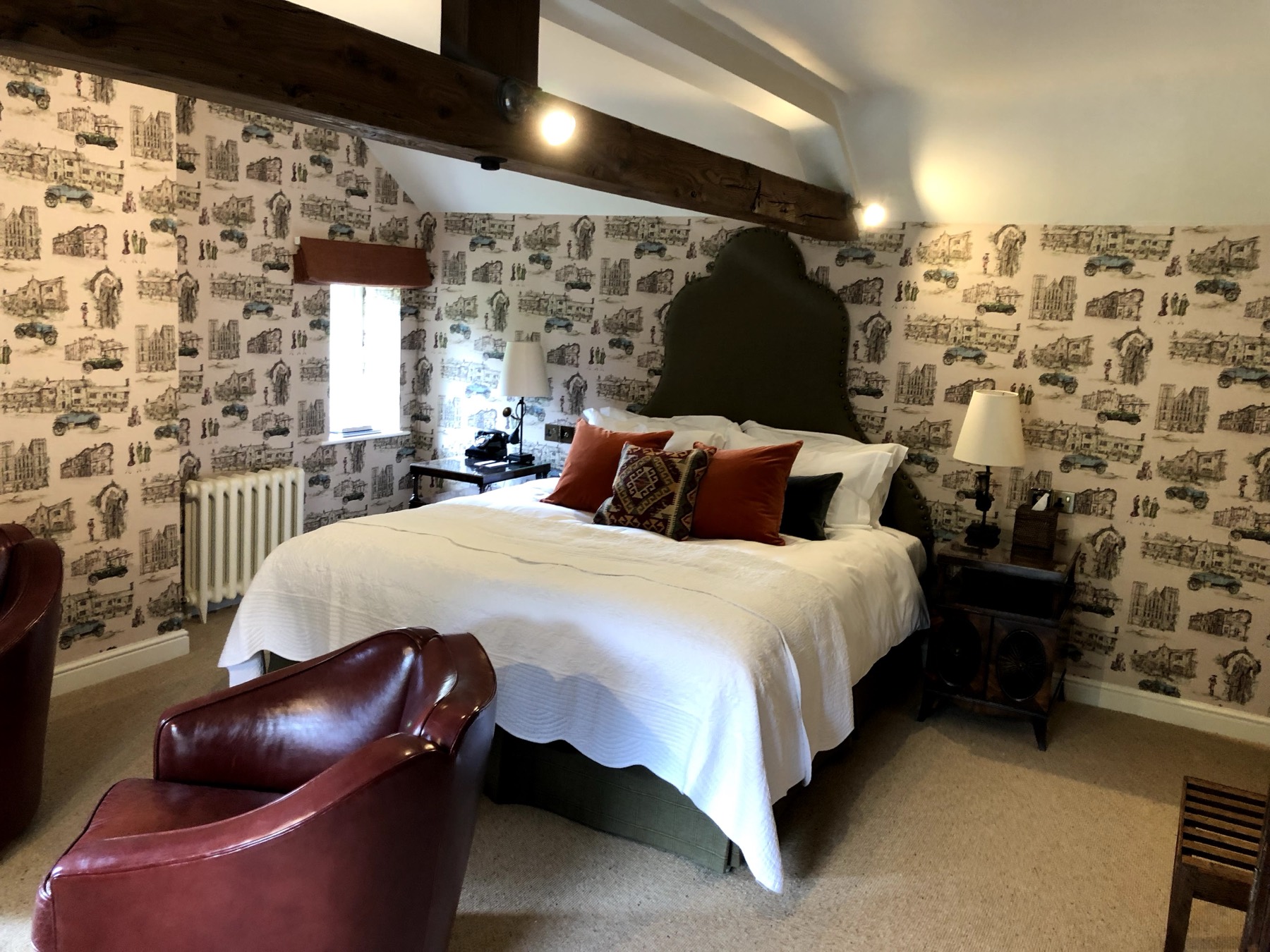 Beamed bedroom in a period property — directional ceiling lights and bedside lamps wired around the timbers.