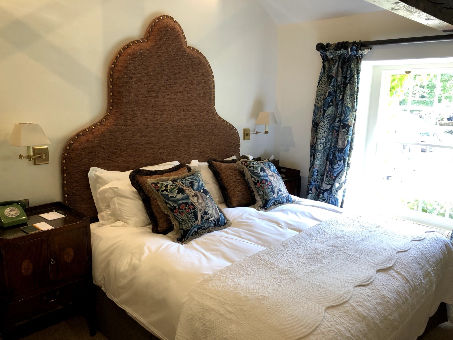 Swing-arm wall lights wired in either side of the bed, switched where you'd actually reach for them.